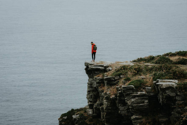 istock Hiker relaxes on coastal mountain cliff 1256427887