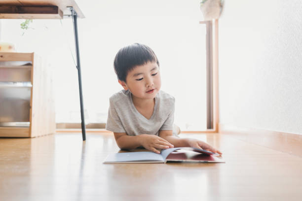 istock Boy reading a book at home 1256428035