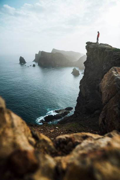 Hiker relaxes on coastal mountain cliff