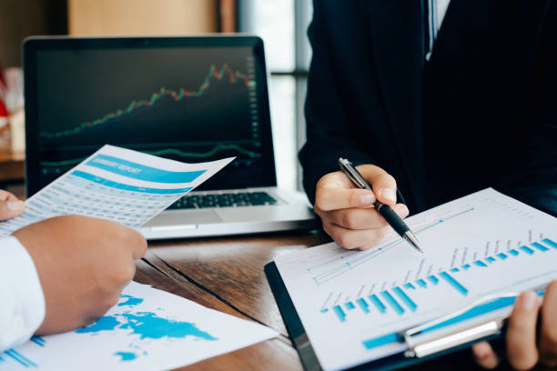 istock two businessmen analysis business graph and papers having discussion in office 1256429659