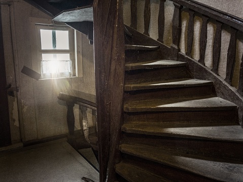 Old staircase with sunbeam coming through a window.