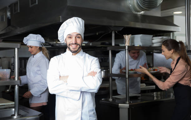 istock Chef in kitchen with busy staff 1256438154