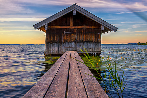 Lonely boathouse with wooden walkway on Lake Chiemsee
