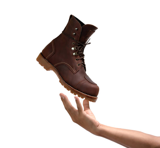istock Men's hand throwing boot leather up to the air isolated on white background. 1256443933