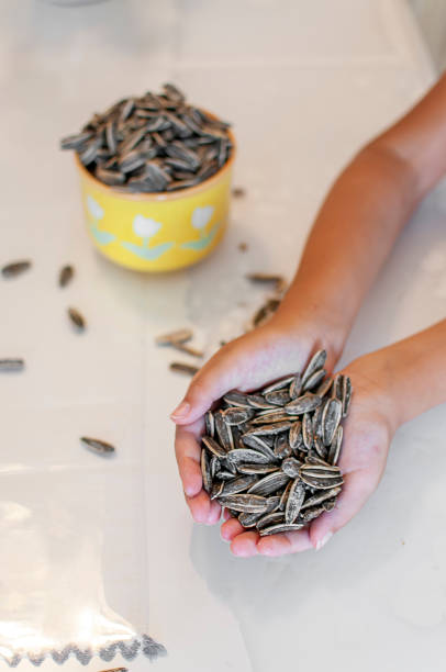 Cute Turkish girl eating sunflower seed to kitchen