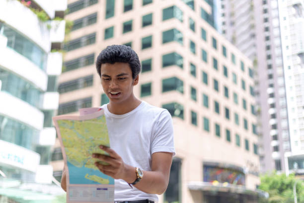 istock A man is standing in the street reading map looking for directions. 1256444099