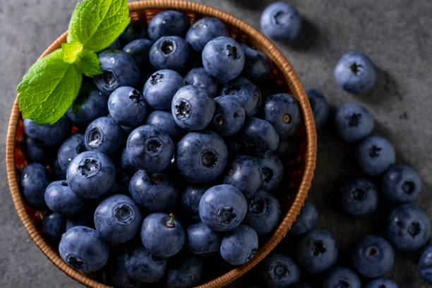 istock Fresh ripe blueberries in basket on dark background. 1256444135