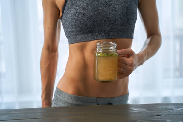 Woman drinking a hot drink. Sporty woman with a cup bone broth stock photo