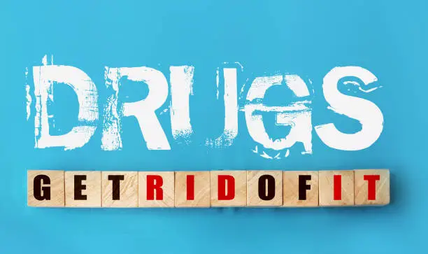Phrase Drugs - get rid of it on sky blue background and on wooden cubes with letters. Top view. Stop drug abuse, Addictions concept.