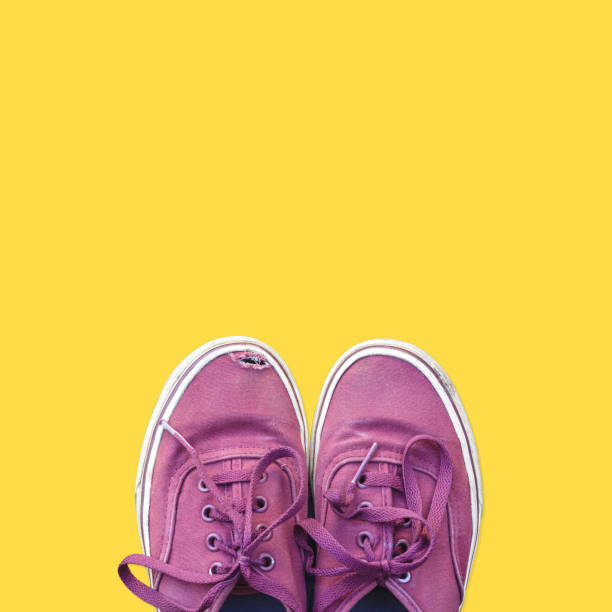 istock Old red sneakers on yellow background 1256449066