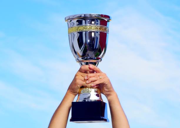 istock The winner takes it all. Champion winner trophy cup on sky background. 1256450432