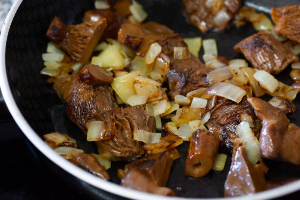 istock Mushrooms with onion on frying pan 1256450500