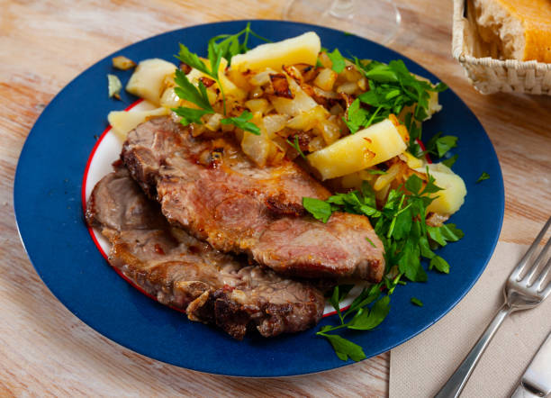 istock Appetizing fried pork with potatoes and herbs 1256450513