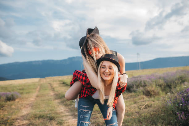istock Smiling girlfriends having fun in piggyback ride 1256450932