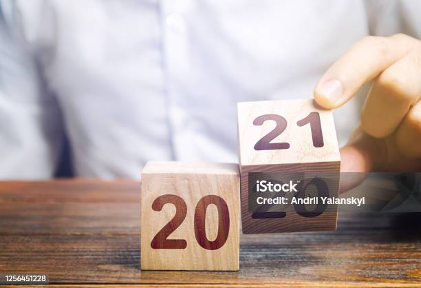 Hand Flips A Block Changing 2020 To 2021 New Year Beginning Holidays And Christmas Trends And Changes In The World Build Plans New Normal Summing Work Done Keep Up With Everything Planned Stock Photo - Download Image Now