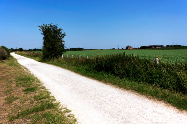 Generic path footpath rolling landscape walking hiking rambling trekking fitness exercise English Midlands UK sunlight lush green agricultural land farmland.