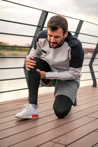 istock Young Athlete is Having Knee Problems while Jogging in the City 1256452382