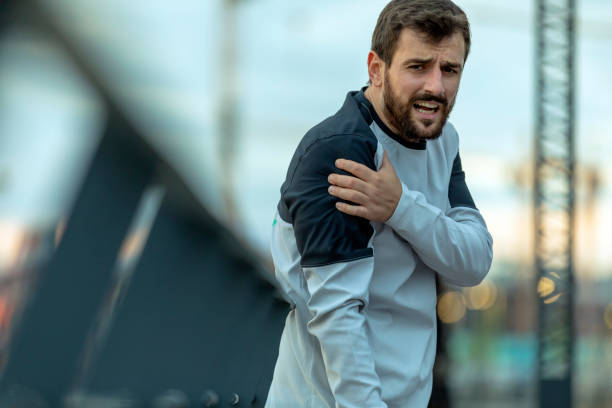 istock Young Athlete is Having a Shoulder Problems while Jogging in the City 1256452394