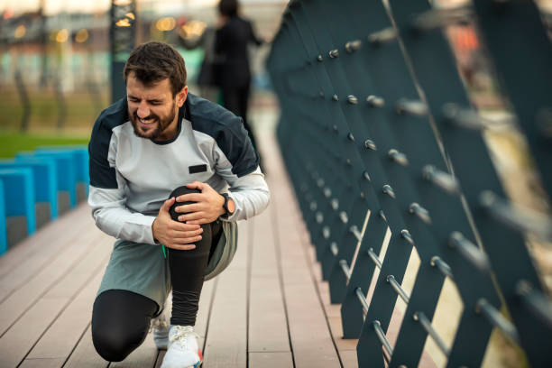istock Young Athlete is Having Knee Problems while Jogging in the City 1256452561
