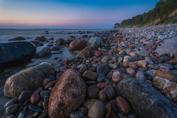 istock rocky seashore, colorful sunset on the background, long exposure 1256453434