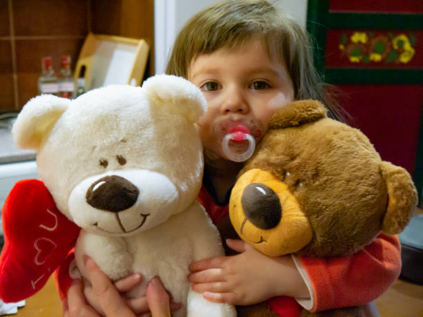 istock Two-year-old girl with two teddy bears 1256453475
