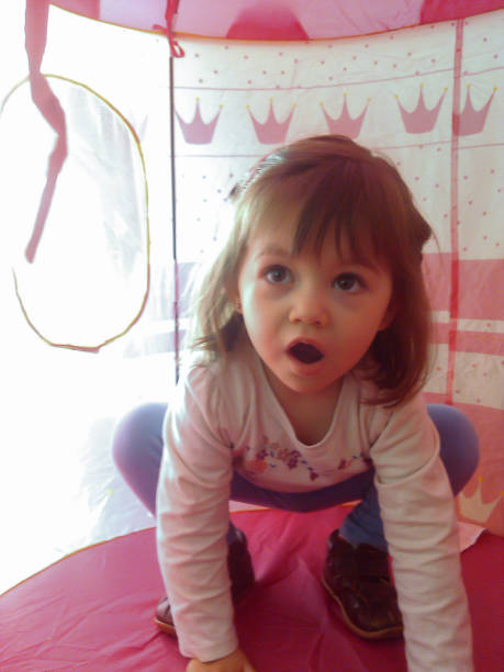 istock Little girl playing inside her little pink tepee 1256453619