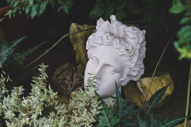 istock Gypsum statue of Apollo's head in plants. 1256455921