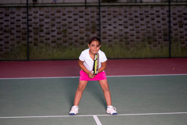 una ragazza è pronta per il servizio sulla linea di base presso il campo duro - tennis baseline fun sports and fitness foto e immagini stock