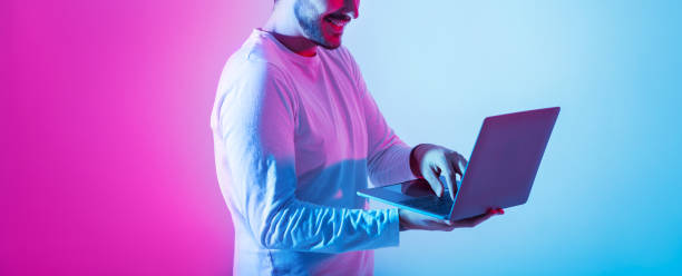 istock Freelance and work remotely. Contented guy use laptop and holds in hands 1256457862