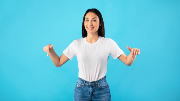 istock Happy girl pointing fingers down at copy space 1256459258