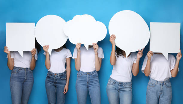 istock Women Holding Speech Bubbles In Front Of Heads, Blue Background 1256460657