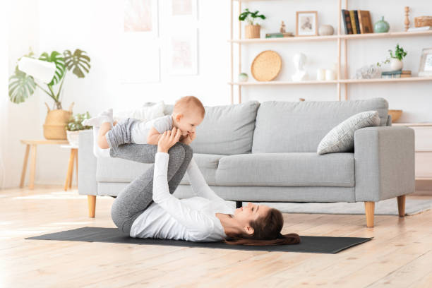 sport with baby. fit mom exercising with her toddler son at home - mother exercising baby dieting imagens e fotografias de stock