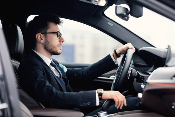 istock Young business man driving alone in his new car 1256463021