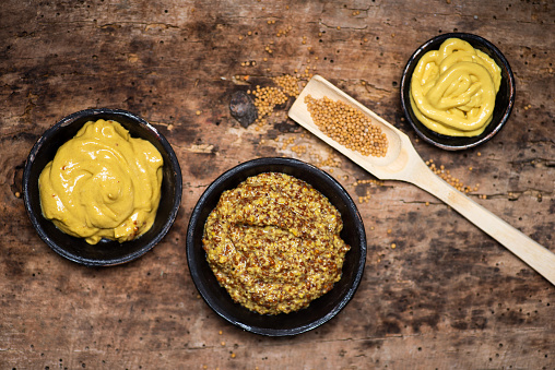 Wholegrain mustard in a bowl on a table top view