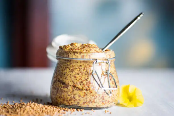 Wholegrain mustard in a jar on a table closeup
