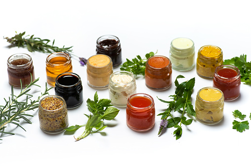 Large collection of sauces and spiced spreads in small jars isolated flat lay. Various herbs and dressings as mayo ketchup mustard soy sauce and many more