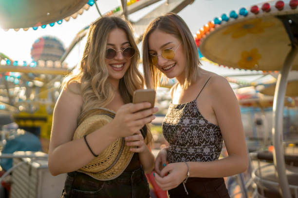 istock Happy girlfriends are make fun together in fun fair 1256466321