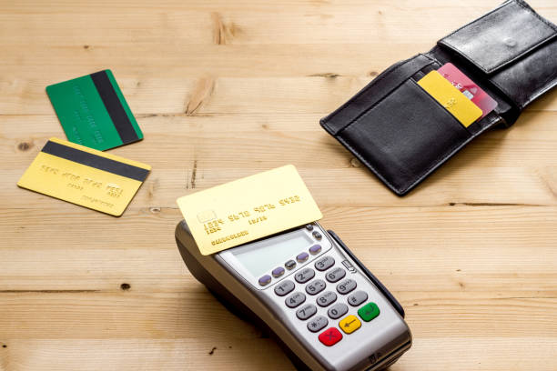 istock Payment by credit card. Terminal on wooden table 1256466540