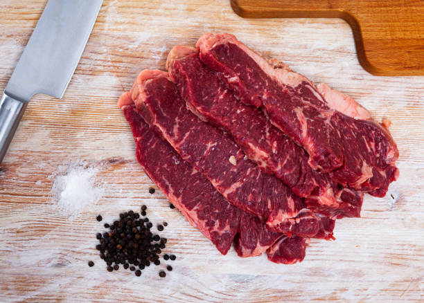 istock Sliced raw marbled veal steaks with peppercorns 1256467418
