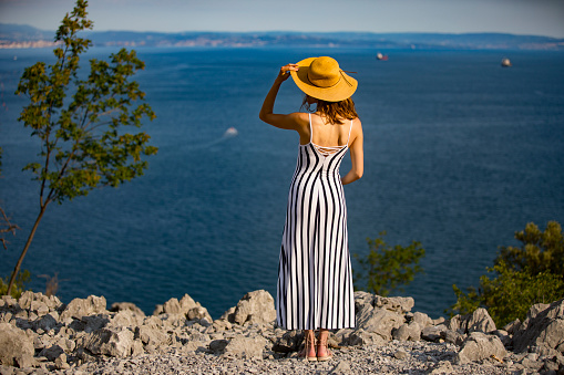 Young Woman With a Hat Looking at View on the Sea.
