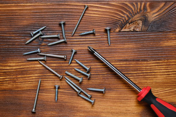 istock Screwdriver with screws on a wooden background top view. 1256471021