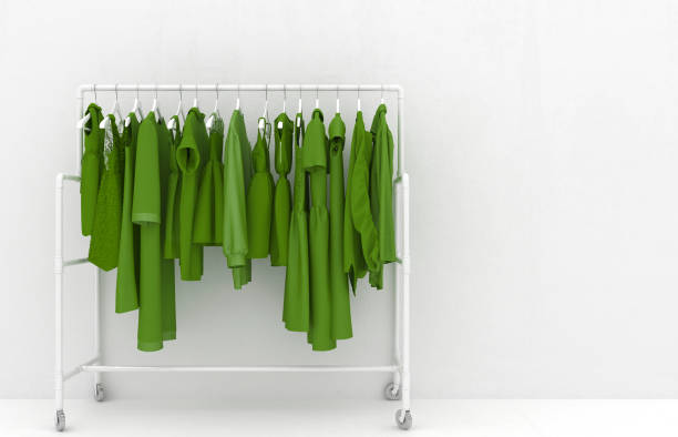 aufhänger mit grüner damenkleidung vor dem hintergrund einer weißen wand. monotone grüne kleidung. kreative konzeptionelle illustration mit kopierraum. 3d-rendering. - clothing closet hanger dress stock-fotos und bilder