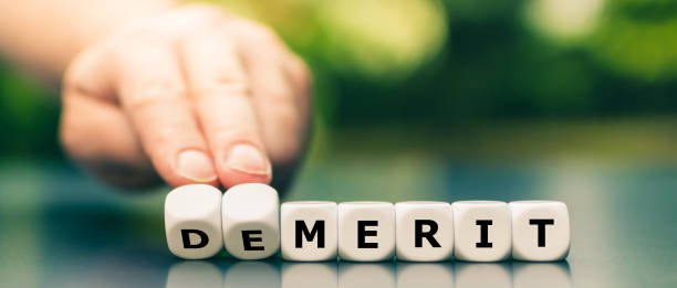 istock Hand turns dice and changes the word demerit to merit. 1256476282
