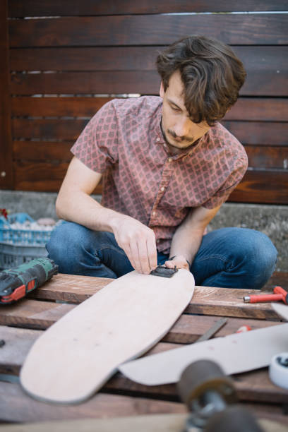 istock Handyman fitting up skateboard while squatting in yard 1256477652