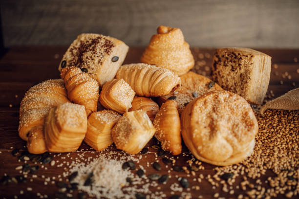 Pastries, grain and sesame on wooden table