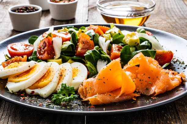 istock Smoked salmon with hard-boiled eggs, avocado and vegetables on wooden table 1256481250