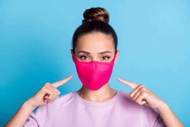 Photo of attractive lady keep social distance ignoring people contacting use respirator direct fingers safe face wear protect facial mask stylish sweater isolated blue color background Photo of attractive lady keep social distance ignoring people contacting use respirator direct fingers, safe face wear protect facial mask stylish sweater isolated blue color background topknot stock pictures, royalty-free photos & images