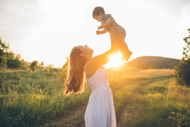 istock Mother and a baby enjoying beautiful sunset 1256483370