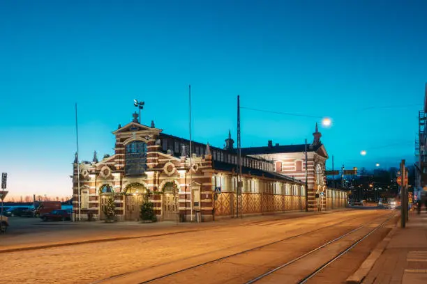 Photo of Helsinki, Finland. Old Market Hall Vanha Kauppahalli In City Center In Lighting At Evening Or Night Illumination. Famous Popular Place In Christmas Holiday