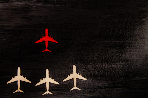 Wooden cut out planes with red plane in front leading them, leadership concept